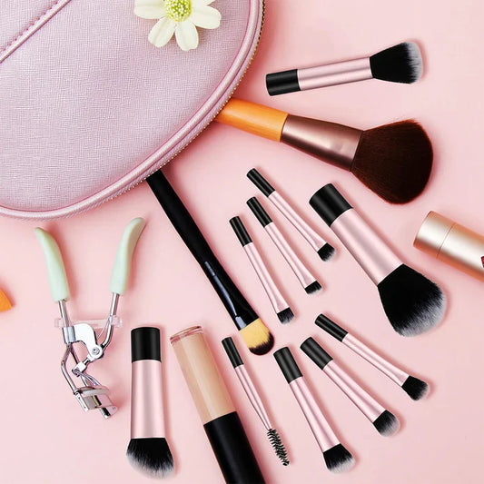 Vynzo Makeup Brush Set โ 12 pcs featuring a variety of brushes and beauty tools on a pink background.