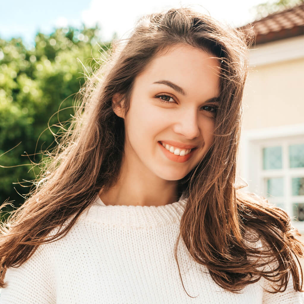 Woman smiling in natural light showing radiant skin after using Japanese Nano Refreshing Liquid.