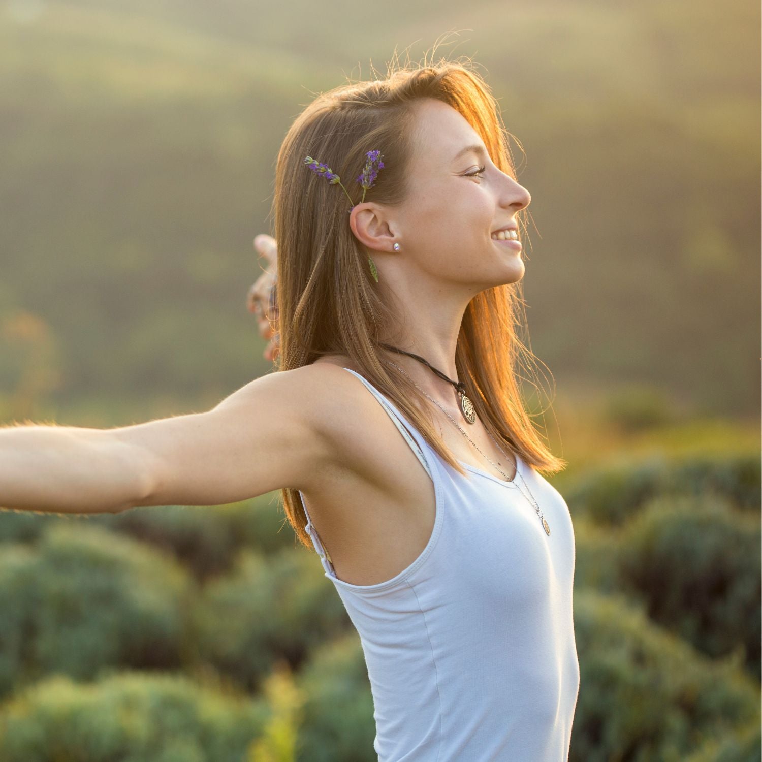 Woman enjoying nature with arms outstretched, embodying refreshment and well-being with Portable Firming Liquid.